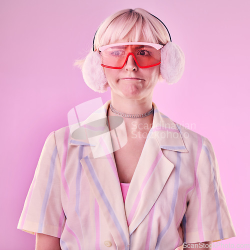 Image of Fashion, gen z and woman in a studio with trendy glasses, earmuffs and outfit with style. Edgy, beauty and female model with cool clothes and a confused face expression isolated by a pink background.