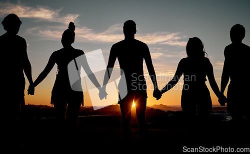 Image of Friends, bonding or holding hands on sunset beach silhouette, nature freedom or community trust support. Men, women or people sunrise shadow in solidarity, team building help or travel mission goals