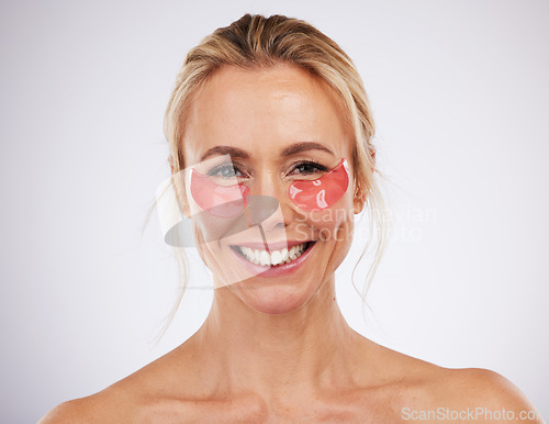 Image of Skincare, eye pads and woman in studio with beauty, self care and natural face treatment. Cosmetic, dermatology and portrait of mature female model with anti aging facial treatment by gray background