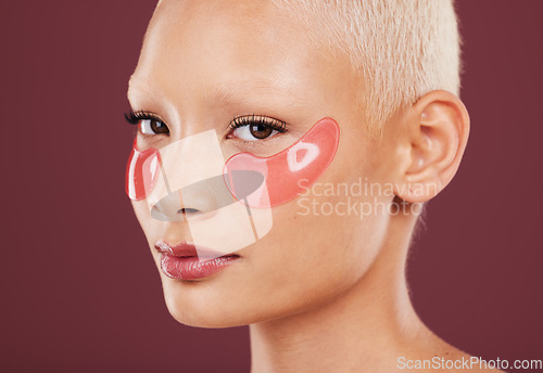 Image of Portrait, eye mask and skincare with a model black woman in studio on a red background for beauty. Face, skin and antiaging with an attractive young female posing to promote a cosmetic product