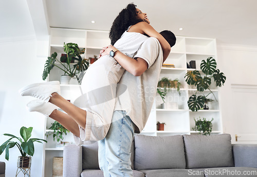 Image of Young couple, hug and jump in new house, real estate and apartment lounge with love. Happy homeowners hugging to celebrate in living room, property investment and dance with care, energy or happiness