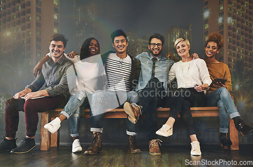 Image of Diversity, friendship and portrait of people with a city background sitting together. Happy, smile and multiracial young friends hugging or embracing on a bench with support, unity and community.