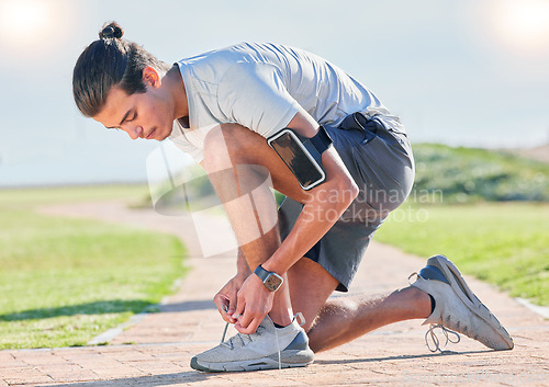 Image of Shoes, fitness man and runner tying laces for running, exercise and training outdoor. Sports, pavement and park run of a athlete doing wellness and health sport for marathon or race in summer