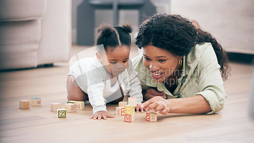 Image of Baby, mother and toy building blocks for child knowledge development on living room floor. Family home, teaching and mom with girl toddler learning and helping with happiness and a smile with love