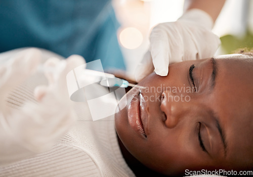 Image of Face, syringe and skincare, black woman at spa with collagen injection for skincare and beauty treatment. Dermatology, cosmetics and person at salon with needle in skin for anti aging facial process.