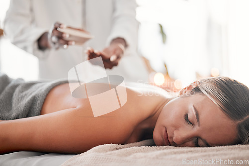 Image of Spa, oil and woman on a table for massage, wellness and skin treatment for peace, zen and relax. Luxury, girl and masseuse with skin product for massaging, therapy and healing in a beauty salon