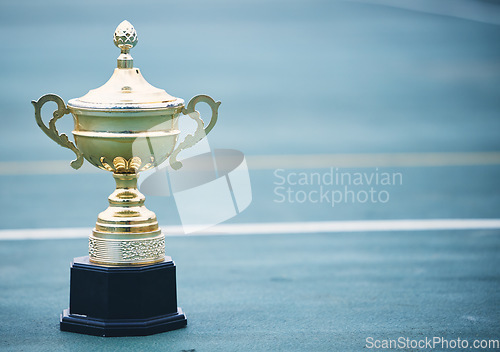 Image of Sports, award and trophy on the floor with no people at court for success, winner or achievement. Prize, victory and sport reward on a ground at an empty stadium for sport, champion and competition