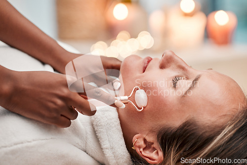 Image of Facial roller, spa and woman getting a massage for self care, wellness and health at beauty salon. Skincare, relax and calm young female doing a luxury natural face or skin treatment for dermatology.