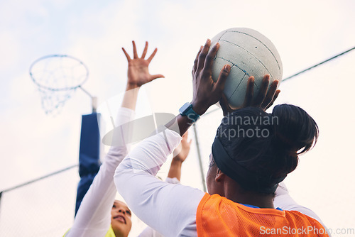 Image of Netball, goal shooter and fitness of a girl athlete group on an outdoor sports court. Aim, sport game and match challenge of a black person with a ball doing exercise and training in a competition