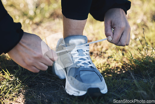 Image of Closeup, shoes ad man runner in a park for training, sports or morning cardio preparation. Hand, sneaker and athletic guy with lacec before run in field, exercise or marathon practice workout outdoor