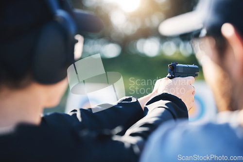 Image of Man, woman and gun training with target, outdoor challenge and aim at police, army or security academy. Shooting coach, pistol or firearm for sport, safety and combat exercise in nature with vision