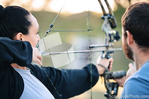 Image of Archery, woman and target training with an instructor on a field for hobby, aim and control. Arrow, practice and archer people together outdoor for hunting, precision and weapon, shooting competition