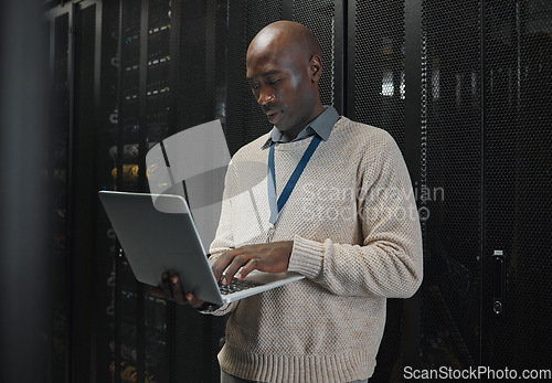 Image of Server room, laptop and black man technician with data center management, system and cybersecurity. Focus, serious and inspection of engineering or programmer person with information technology code