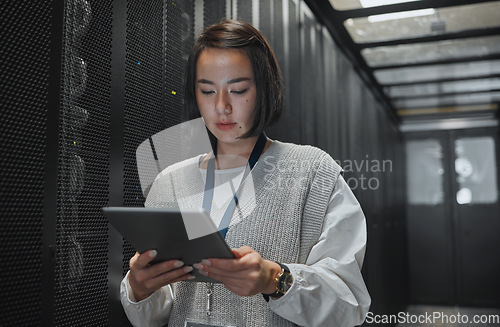 Image of Tablet, server room and security with a programmer asian woman at work on a computer mainframe. Software, database and information technology with a female coder working alone on a cyber network