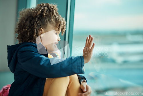 Image of Girl child, wave and airport window for greeting, goodbye and smile for airplane, international transport and travel. Kid, happy and hand gesture by glass for global immigration, young and African