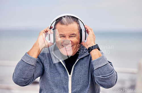 Image of Portrait, music and fitness with a senior man outdoor on the promenade for a cardio or endurance workout. Headphones, running and training with a mature male outside by the beach for exercise