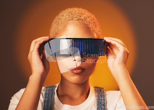 Image of Black woman, vr and futuristic cyberpunk glasses in online metaverse app or game or video on brown background. Virtual reality, future fashion and digital augmented reality goggles on model in studio