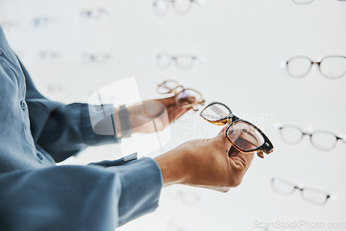 Image of Glasses choice, black woman hands and customer with store worker at optician looking at lens. Eye consulting, smile and eyewear shopping in a frame shop for vision and prescription exam for eyes