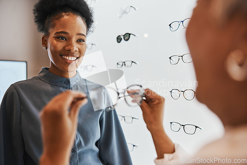 Image of Glasses, black woman and retail customer with store worker and optician looking at lens. Eye consulting, smile and eyewear assessment in a frame shop for vision test and prescription exam for eyes