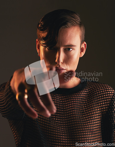 Image of Gender neutral person, fashion and hand on dark background, trendy and edgy art. Creative, gen z and beauty, pointing and sexy with cosmetics, young and non binary with designer clothes in portrait