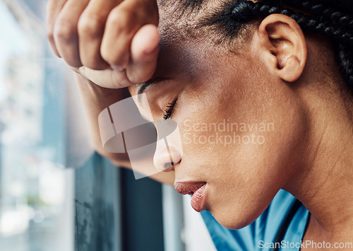 Image of Doctor, black woman stress or anxiety by window in hospital, workplace and tired in healthcare job, pain or headache. Burnout nurse, sad or exhausted in medical clinic or depression in health clinic