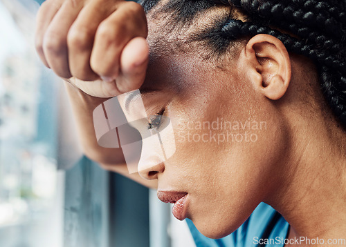 Image of Doctor, black woman burnout and anxiety in hospital, workplace and tired in healthcare job, stress or headache. Nurse, sad and exhausted in medical clinic or depression in health hospital by window