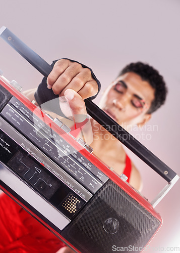 Image of Closeup, retro radio and black man with music, makeup and fashion against grey studio background. Zoom, boom box and cassette player with queer male, gay and transgender person with sounds and music