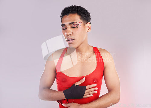 Image of Punk, fashion and makeup man isolated on studio background for creative, art and gen z cosmetics. Gay, lgbtq and queer model or black person with danger, red and fight for love and beauty aesthetic