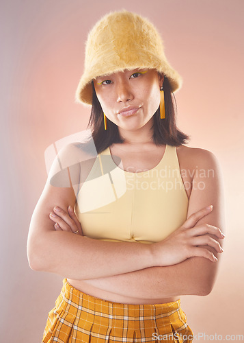 Image of Asian woman, fashion and confident, gen z and portrait, yellow aesthetic and edgy on studio background. Streetwear style, beauty and cosmetics, female and empowerment, attitude with arms crossed