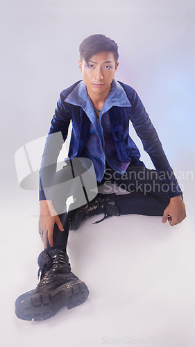 Image of Makeup, portrait of gay man on floor in fashion and pride in Indonesia isolated on purple background. Confidence, aesthetic and lgbt model with beauty in studio, non binary and gender neutral design.