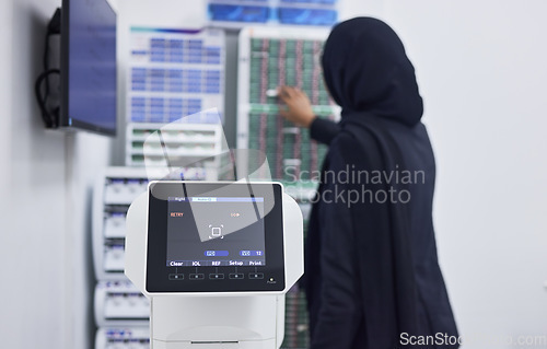 Image of Optometry, screen for eye exam and Muslim optician with machine for vision test, eyesight and optical assessment. Healthcare, ophthalmology and optometrist working on medical camera for eyes scan