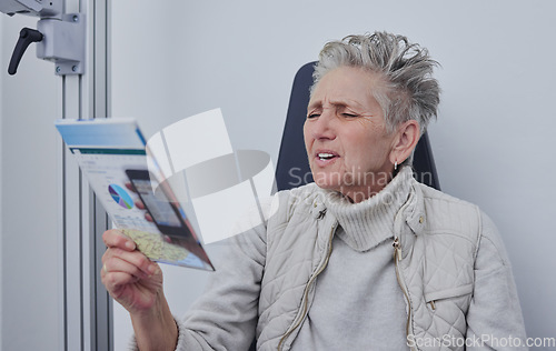 Image of Senior woman, optometrist office and reading for snellen test, nearsighted problem or hospital consultation room. Elderly patient, healthcare or paper for eyes, focus and retirement at clinic check