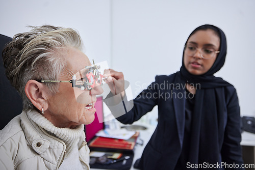 Image of Eye exam, frame and senior woman with optometrist in clinic for vision test, eyesight and optical assessment. Optometry, healthcare and Muslim optician with patient, trial lens and medical eyeglasses