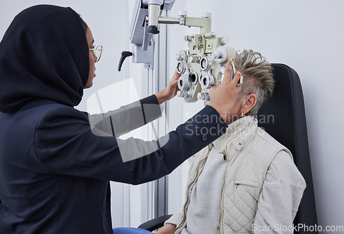 Image of Eye exam, healthcare and senior woman with optometrist in clinic for testing eyes, eyesight and optical assessment. Optometry, vision and Muslim optician with patient, phoropter and medical machine