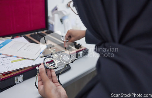 Image of Hands, vision and optometry with an islamic woman at work in eyecare for prescription lenses for sight correction. Doctor, medical or glasses and a muslim female optician working with eyewear