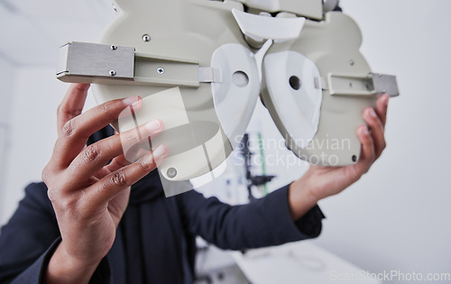 Image of Optometry, machine and optometrist preparing for a eye test in the optic or healthcare clinic. Vision, ophthalmology and hands of a female optician with optical equipment for a exam in a store.