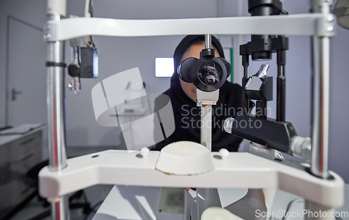 Image of Optometry, healthcare and optometrist doing eye test in the clinic for eyecare and vision wellness. Medical, ophthalmology and muslim female optician doing optical exam with equipment at optic store.