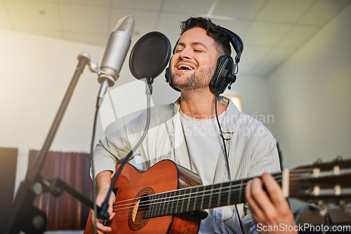 Image of Guitar, microphone and singing in studio for album recording, theatre label or radio musician industry. Man, singer and guitarist headphones for instrument production, theater sound or karaoke media