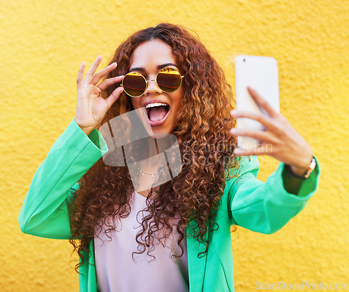 Image of Selfie, fashion and woman with sunglasses on yellow background, color wall and gen z backdrop. Happy young female, trendy style and take profile picture on social media, green clothes and curly hair