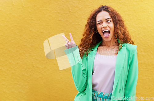 Image of Woman, peace and wink on yellow background, color backdrop and mockup space. Happy female, v sign and hands of cool model for victory, winking and fun mood with happiness, mock up and gen z fashion