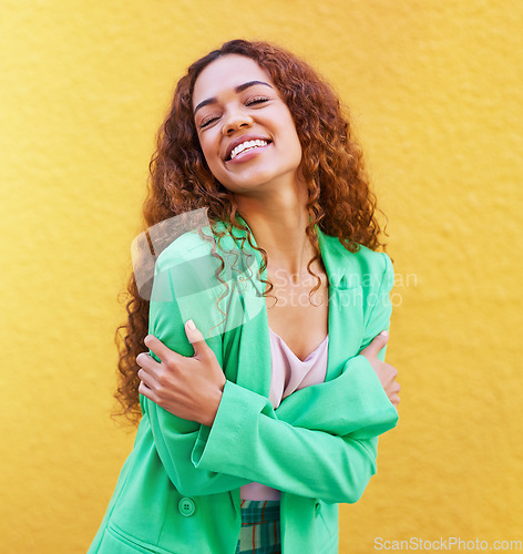 Image of Black woman, fashion and self love on yellow wall background for motivation, beauty and style. Gen z Colombia person with curly hair outdoor for freedom, hug and positive mindset for trend