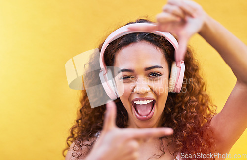 Image of Hands, frame and portrait of woman with headphones on yellow background for profile picture. Face, female and finger framing with music for perspective, selfie and vision of happiness, smile and tech