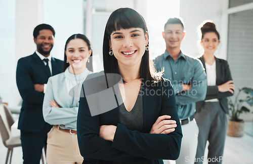 Image of Portrait, collaboration and leader with a manager woman and her team standing arms crossed in the office. Vision, teamwork or diversity and a female manager posing at work with her employee group