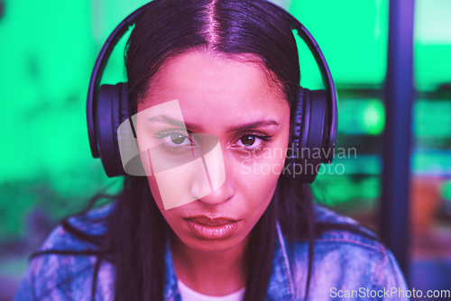 Image of Headphones, portrait or gaming woman in neon home with focus, strategy or serious face expression for esports. Zoom, player or video gamer in night house with cyberpunk music or challenge mindset