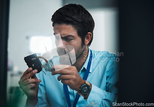 Image of Serious man, IT technician and electrical repair for hardware fixing, technology or problem solving at office. Focused male engineer or handyman holding electronic tech component for computer repairs