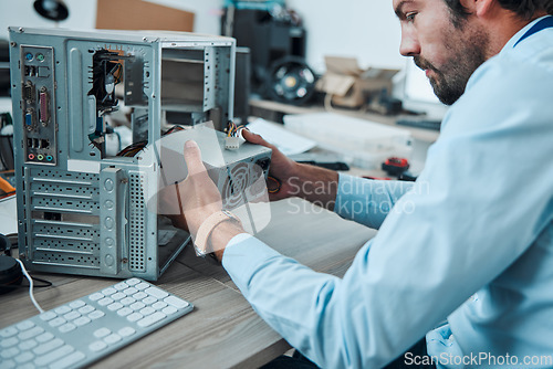 Image of Engineering, technician and man fixing the hardware of a computer in workshop or office. IT, technology and male professional doing maintenance or repairs on microcircuit or motherboard in workplace.