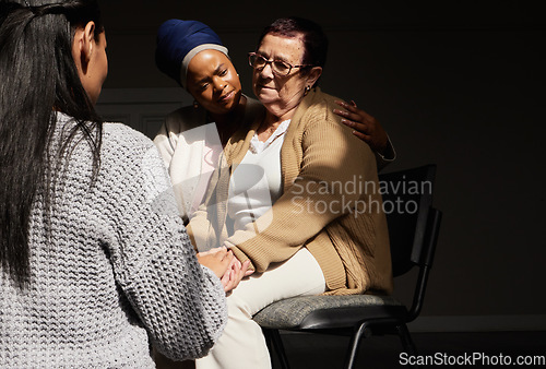 Image of Support, holding hands and senior woman in group therapy with women understanding, sharing feelings and talking in session. Mental health, grief or depression, people with therapist sitting together.