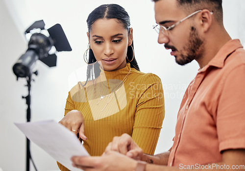 Image of Documents, collaboration or planning with a photographer and model talking in a studio for creative production. Teamwork, designer or fashion with a designer man and woman at work on a magazine shoot