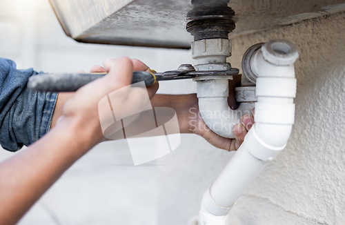 Image of Hands, tool and pipe with a man plumber fixing a water system as a DIY handyman for maintenance. Building, construction or plumbing with a professional contractor working to install pipeline drainage