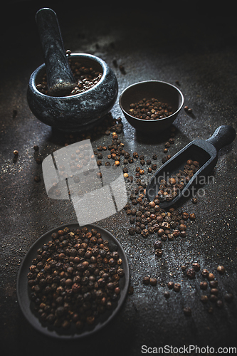 Image of Black peppercorns spilled out of a scoop